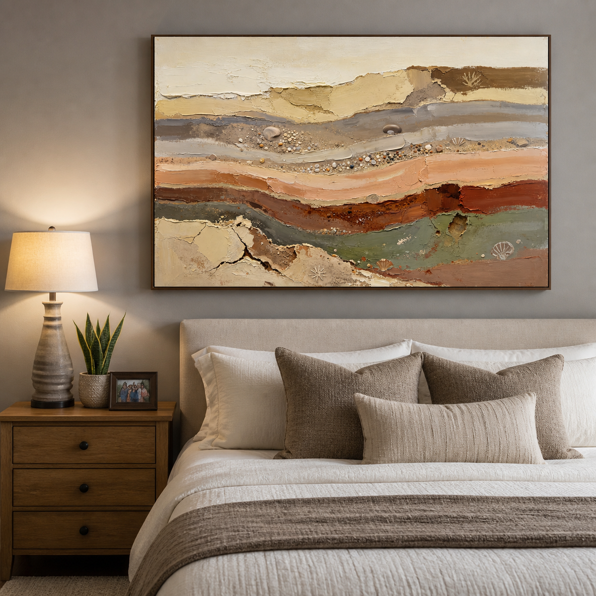 Neutral abstract coastal wall art with layered earth-tone textures, pebbles and seashell details displayed above a dining table.