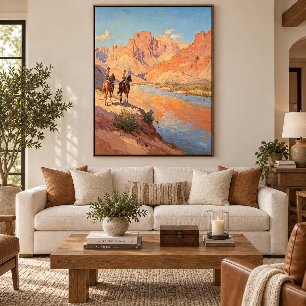 Two cowboys on horseback overlooking a blue river beneath towering sunlit red canyon cliffs.