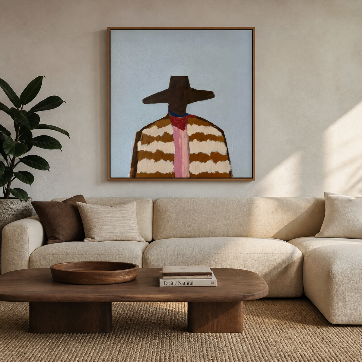 Western cowboy portrait with a wide brown hat, striped jacket and pink necktie displayed above a neutral sofa.