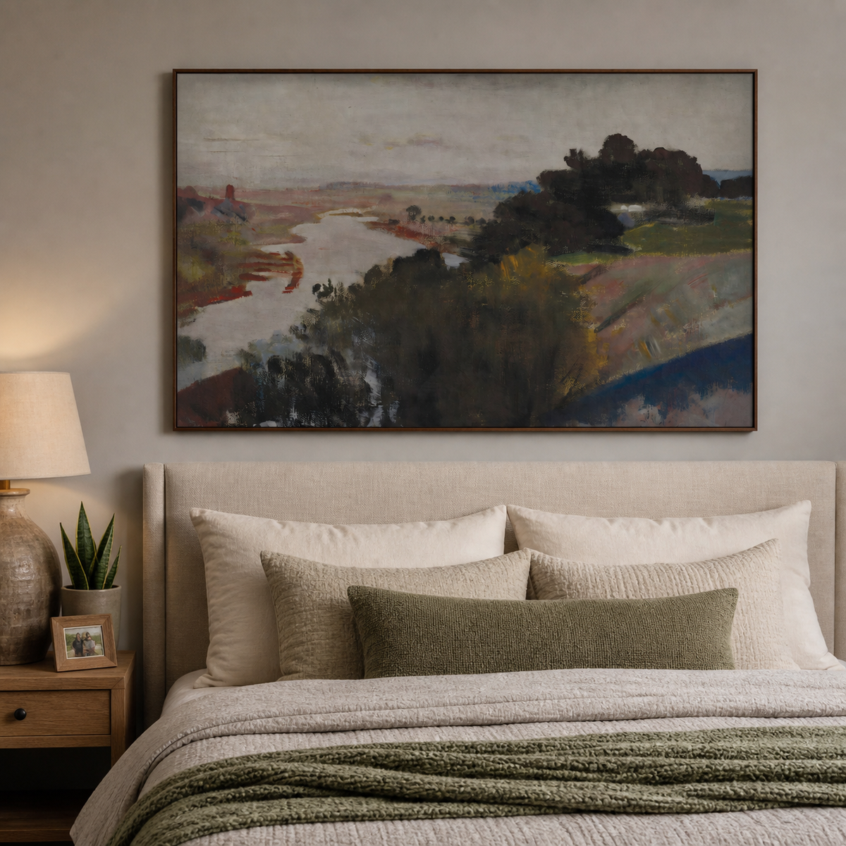 Abstract river landscape wall art with dark trees and muted earth-tone fields displayed above a wooden dining table.
