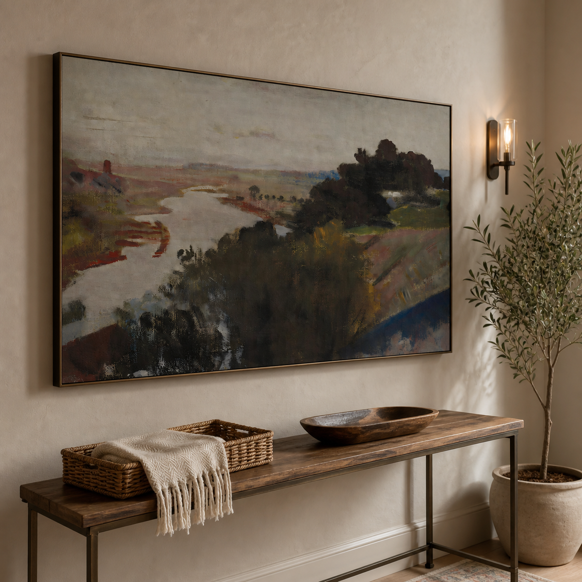 Abstract river landscape wall art with dark trees and muted earth-tone fields displayed above a wooden dining table.