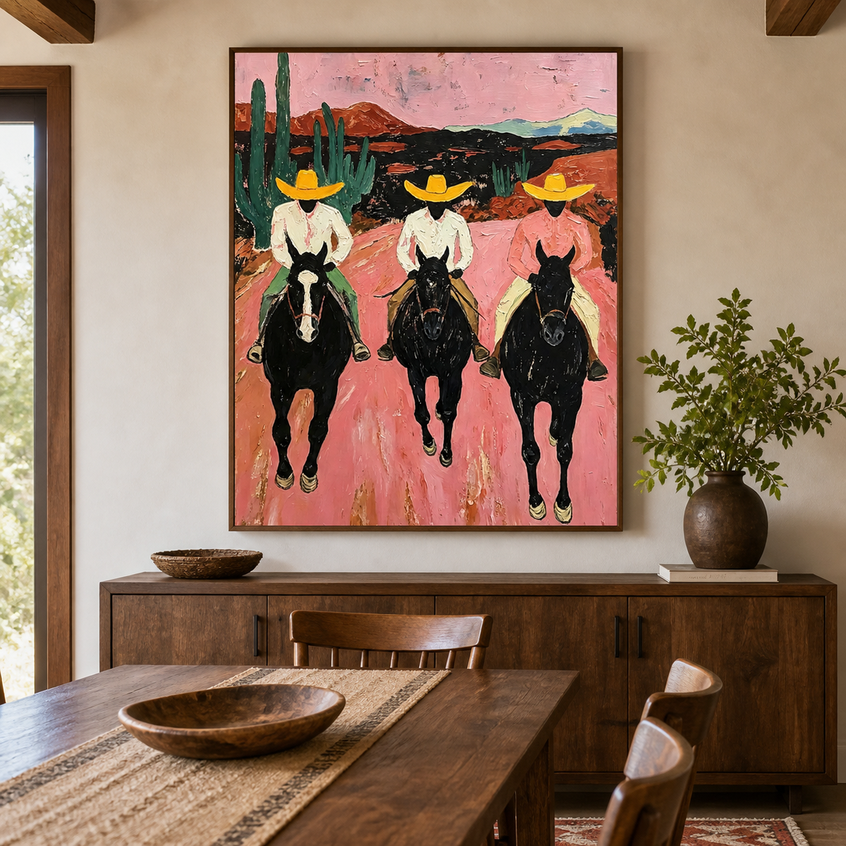 Three cowboys in yellow hats riding black horses through a pink desert on vertical wall art