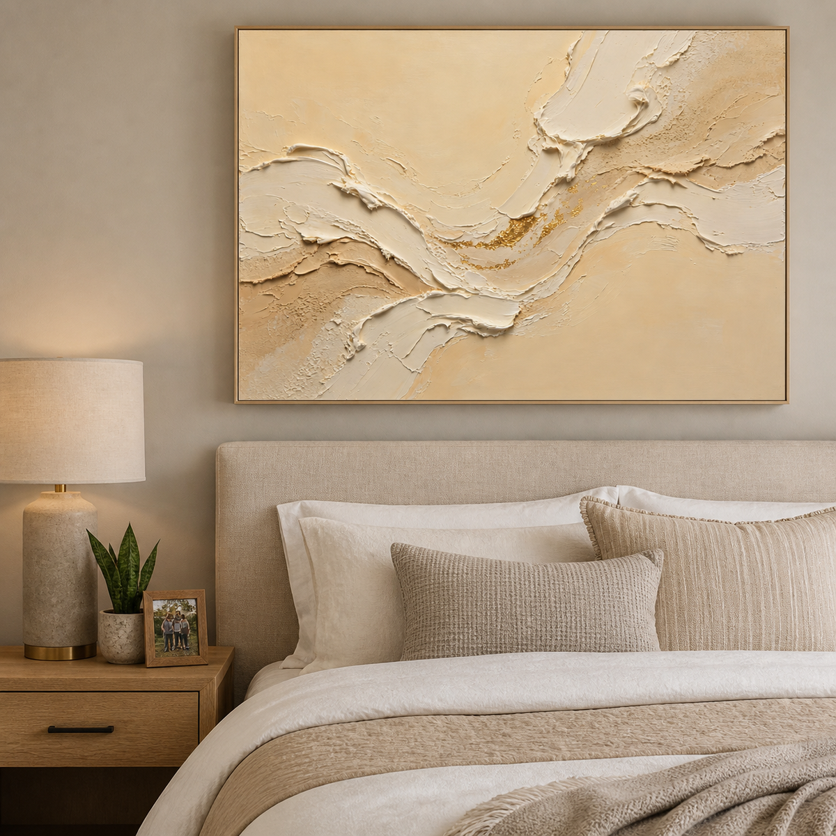 Wide neutral textured wall art with layered ivory and beige wave forms and gold accents displayed above a living room sofa.