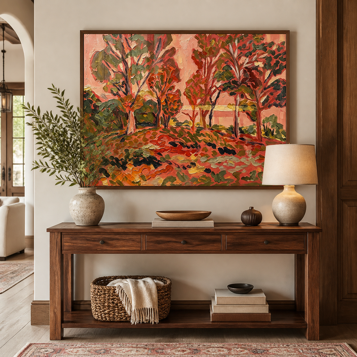 Red forest wall art with colorful autumn trees and warm orange ground displayed above a neutral sofa.
