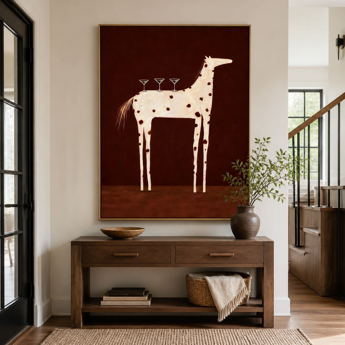 White spotted horse wall art with three cocktail glasses displayed above a wooden entryway console.