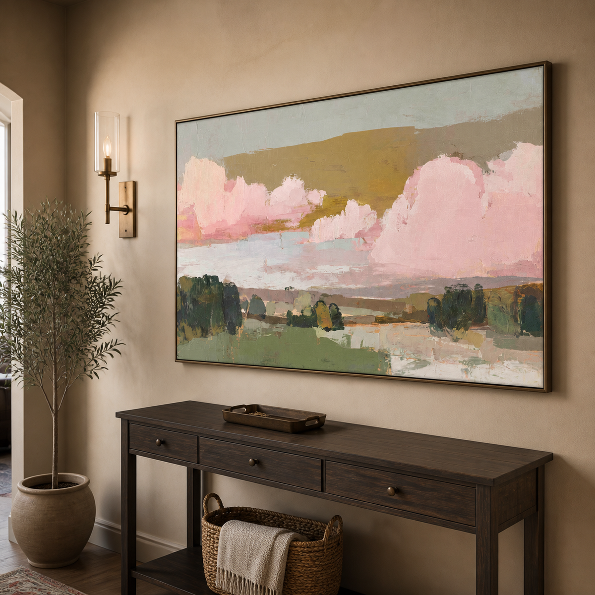 Pink and green abstract landscape wall art with blush clouds and layered fields displayed above a neutral living room sofa.