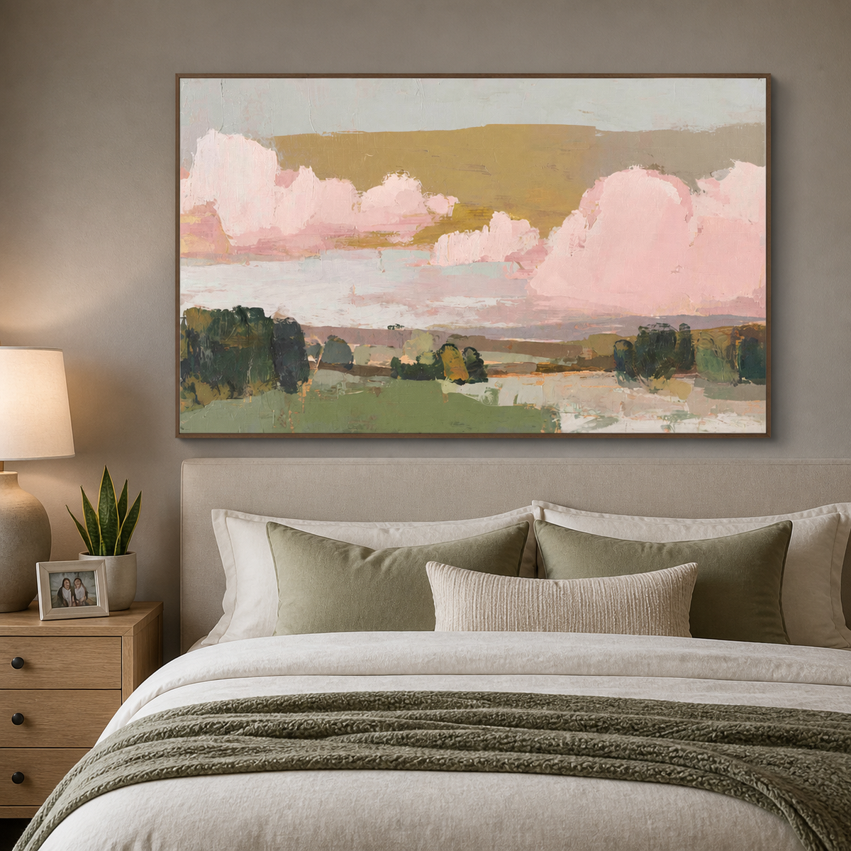 Pink and green abstract landscape wall art with blush clouds and layered fields displayed above a neutral living room sofa.