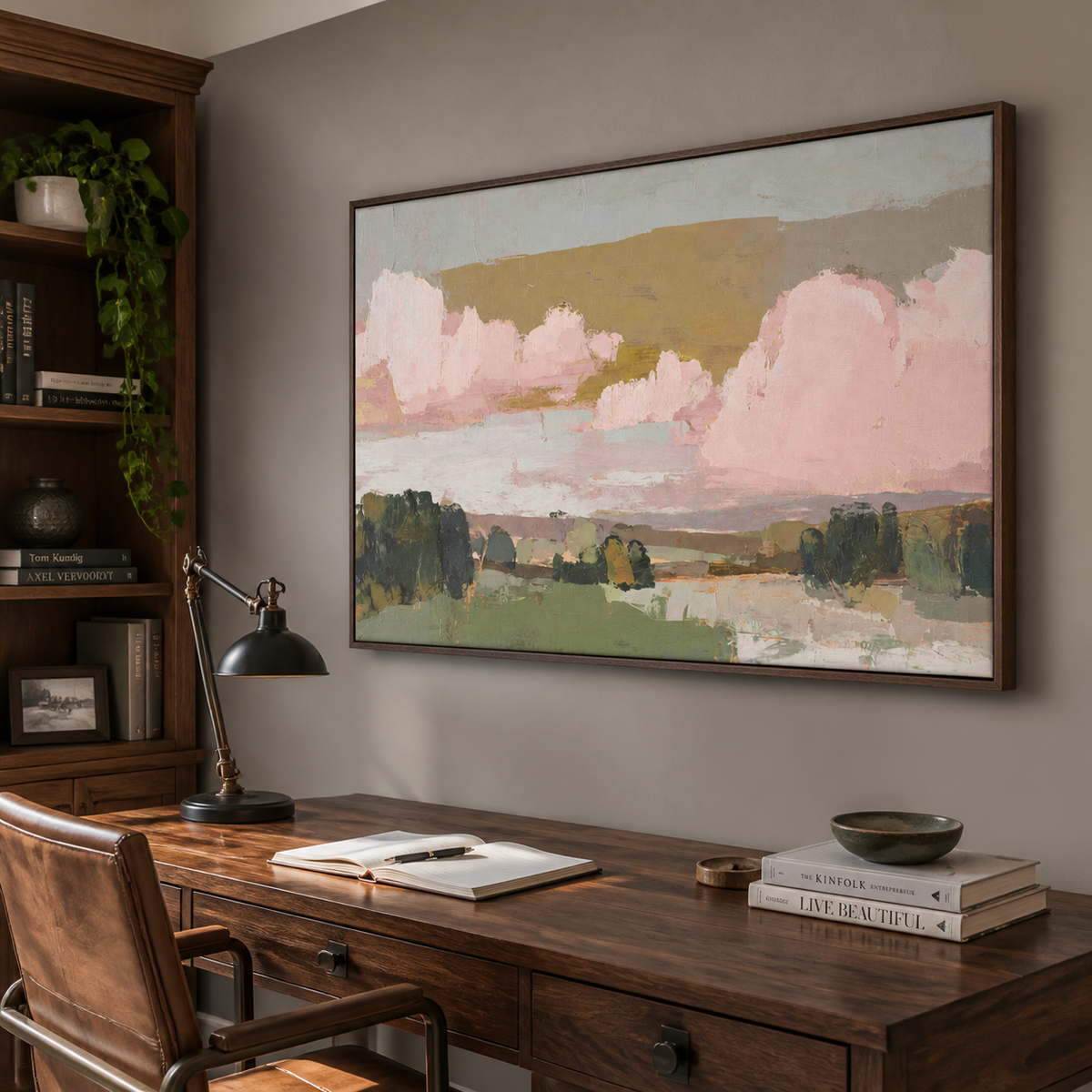 Pink and green abstract landscape wall art with blush clouds and layered fields displayed above a neutral living room sofa.