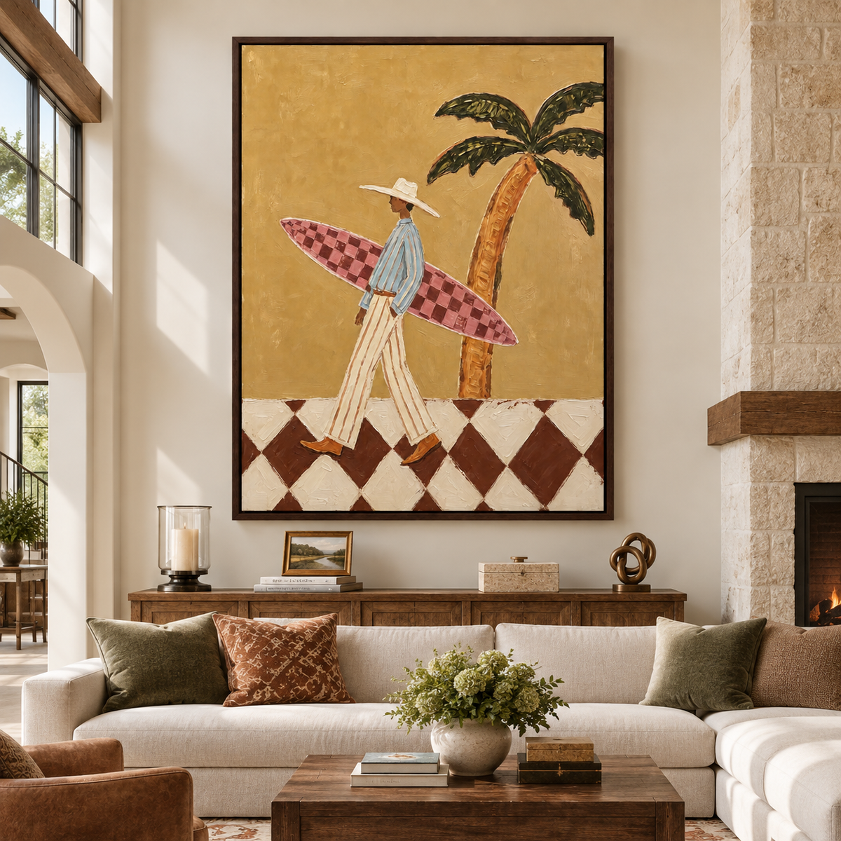 Large vertical surfer wall art showing a person carrying a pink checkerboard surfboard beneath a palm tree above a cream sectional sofa