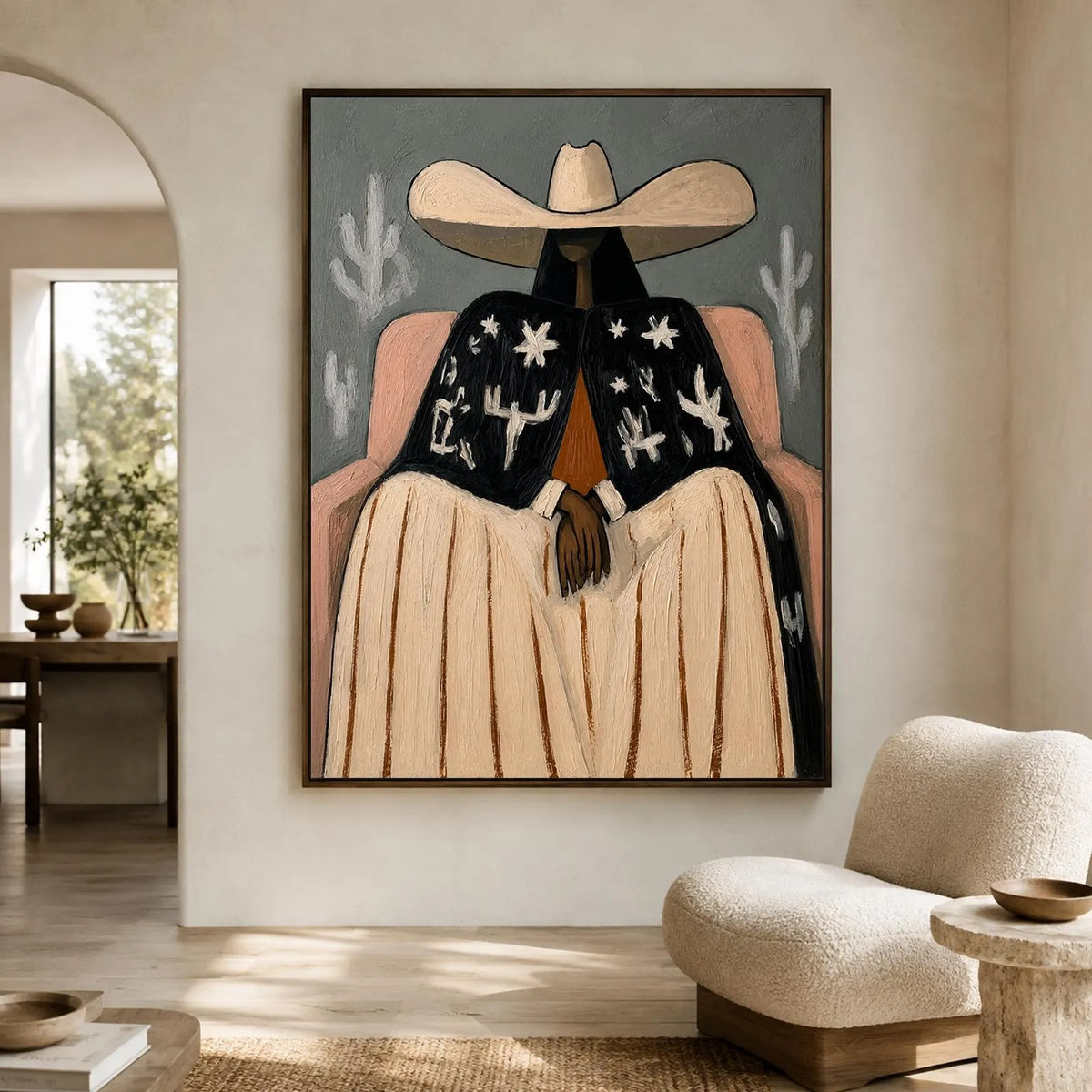 A seated cowgirl in a broad cream hat, pale skirt and black jacket patterned with white desert motifs against a gray background, shown in room setting 3.