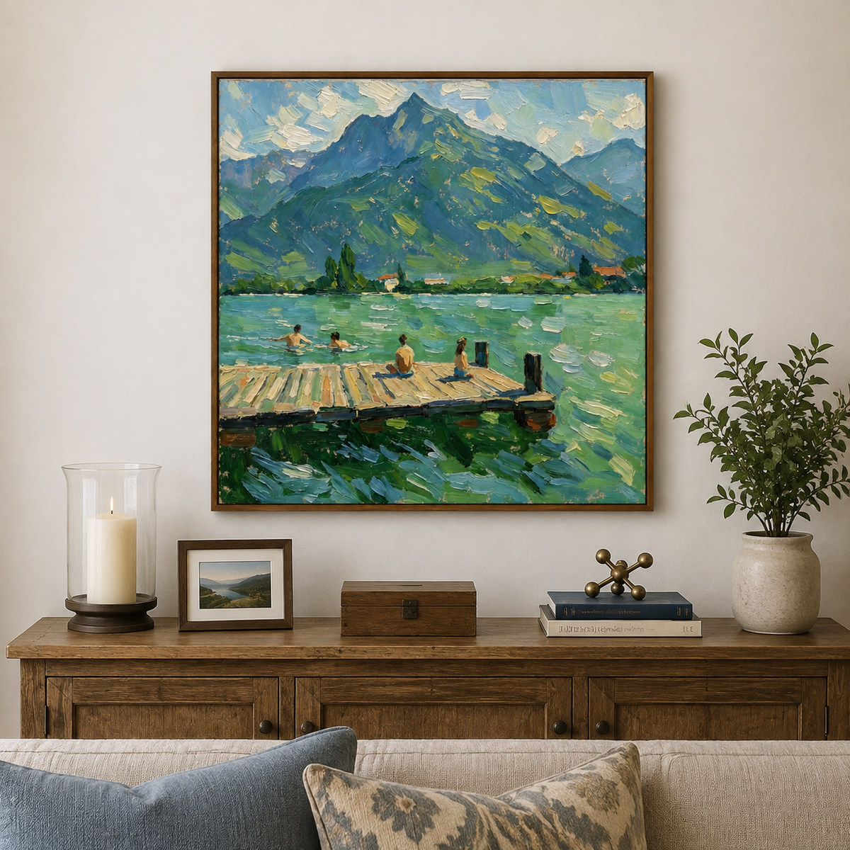 Framed mountain lake oil painting with swimmers and a wooden dock, styled above a living room cabinet.