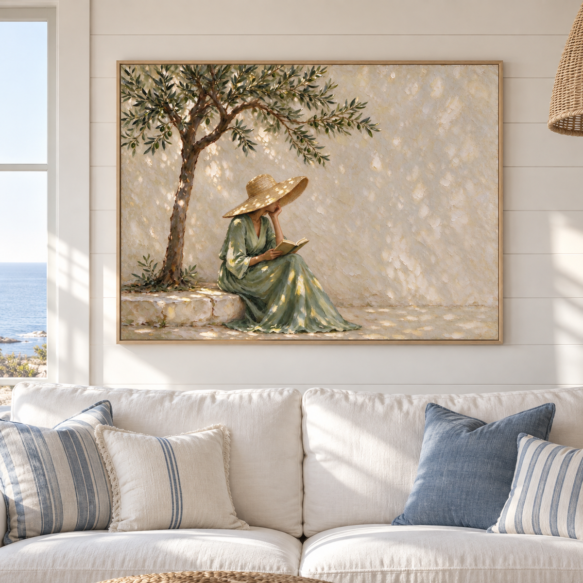 A woman in a green dress resting her cheek on one hand while reading on a stone ledge under a tree, shown in a coastal living room.