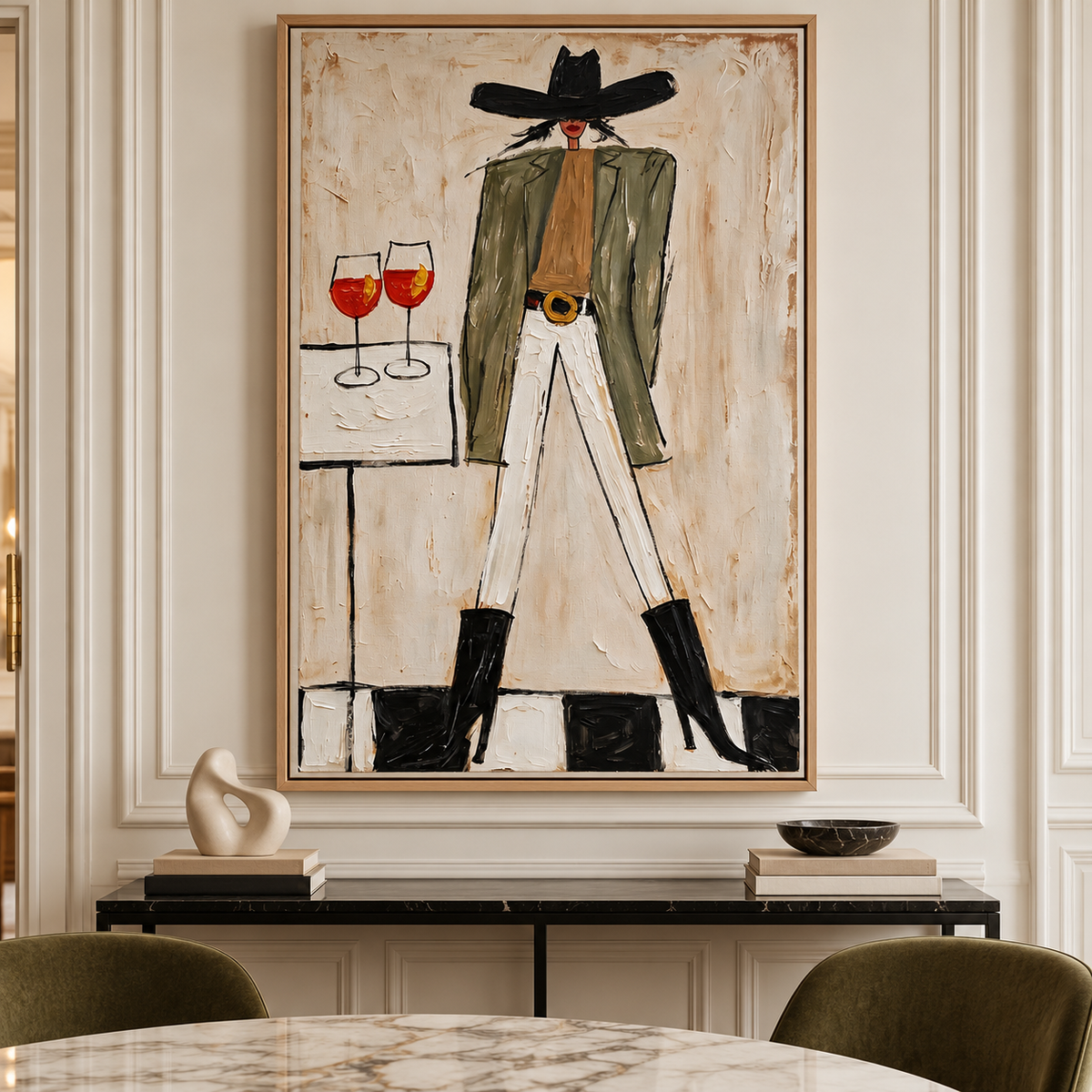 A woman in a wide black cowboy hat, olive-green jacket, white pants and black boots standing beside a small table with two orange-red drinks in stemmed glasses, shown in room setting 1.