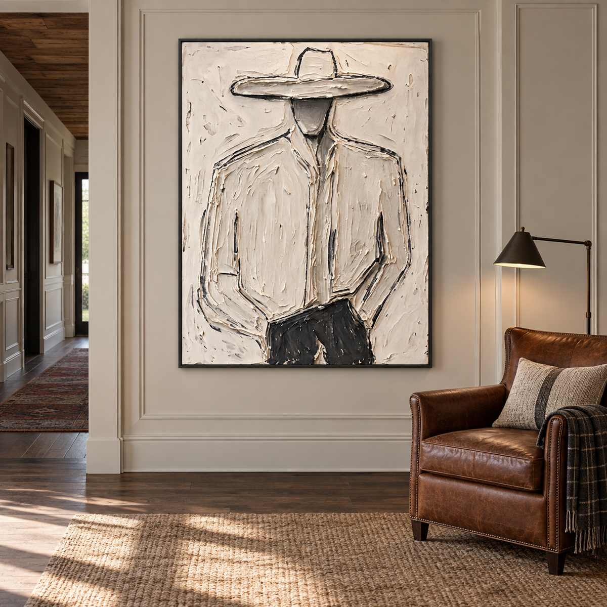 A faceless cowboy in a pale wide-brimmed hat and light shirt with dark trousers against an off-white background, shown in a ranch study.