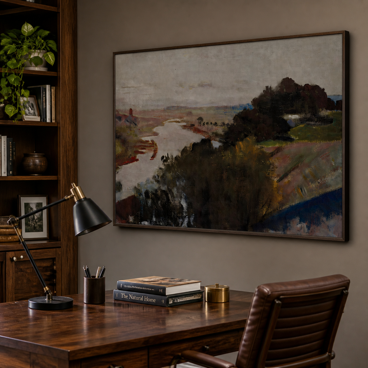 Abstract river landscape wall art with dark trees and muted earth-tone fields displayed above a wooden dining table.