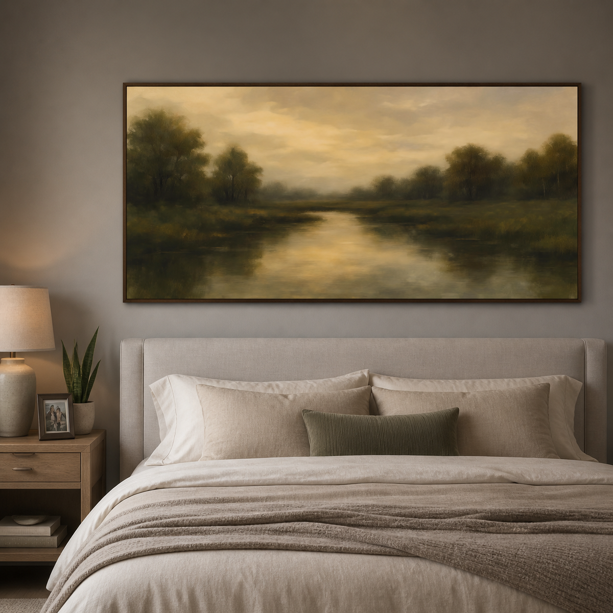 Panoramic moody river landscape wall art with dark green trees and golden reflections displayed above a neutral living room sofa.