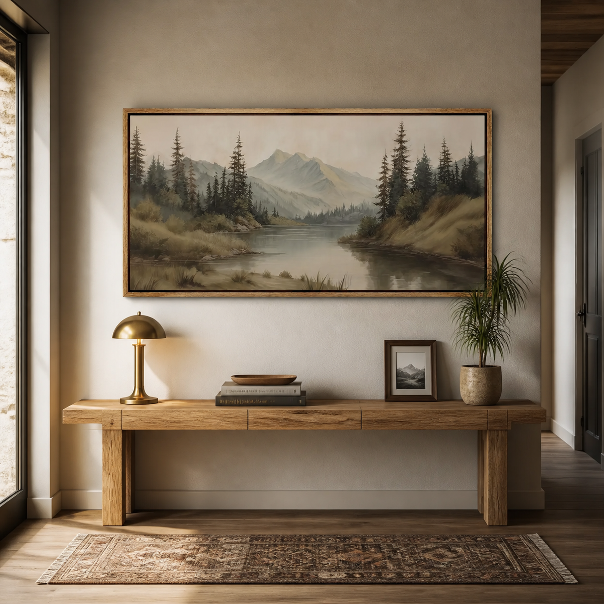 Panoramic mountain lake wall art with tall pine trees and distant peaks displayed above a neutral living room sofa.