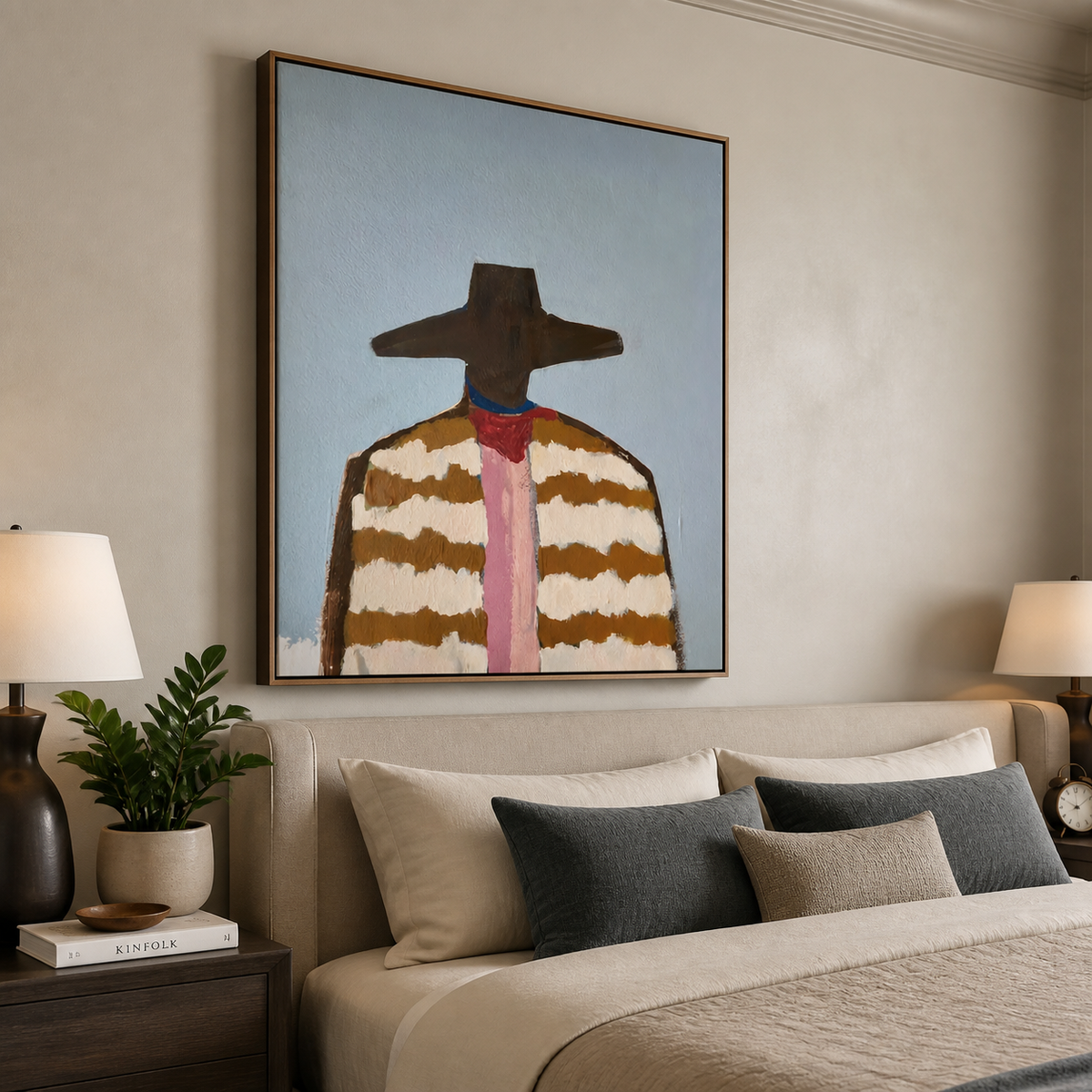 Western cowboy portrait with a wide brown hat, striped jacket and pink necktie displayed above a neutral sofa.