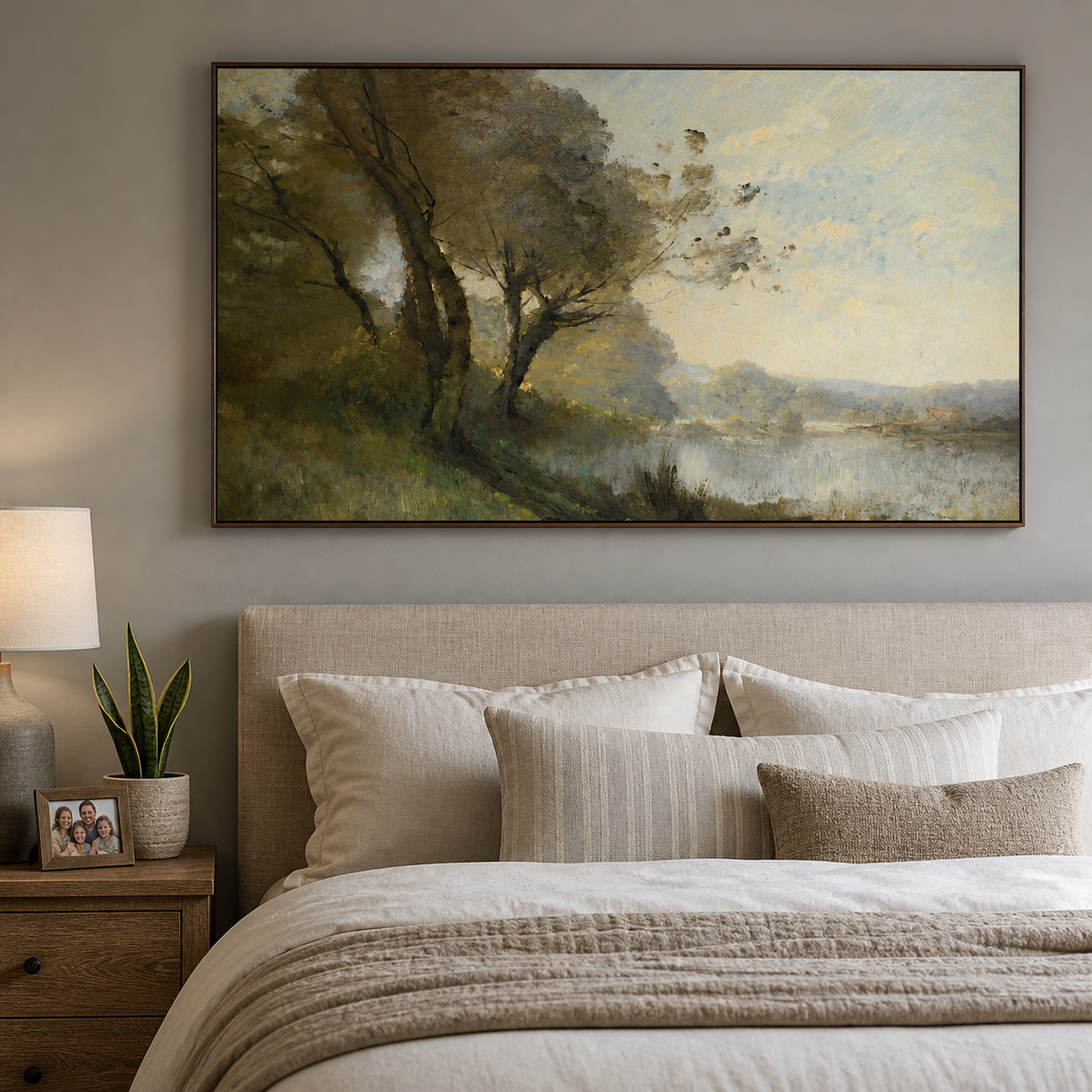 Lakeside landscape wall art with windswept green trees, reflective water and distant hills displayed above a wooden dining sideboard.