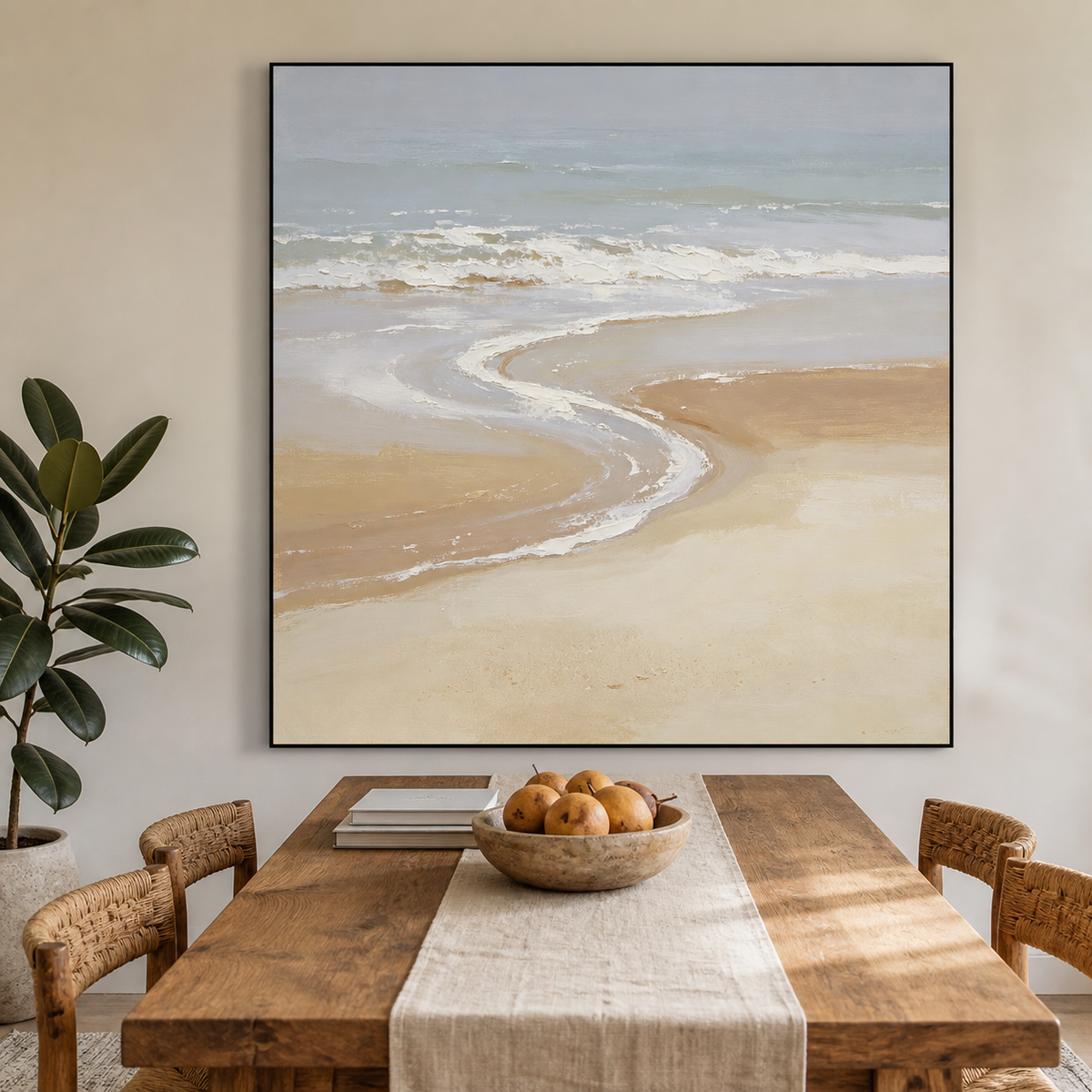 Square neutral coastal wall art with soft blue-gray ocean waves and a curved beige shoreline displayed above a wooden dining table.