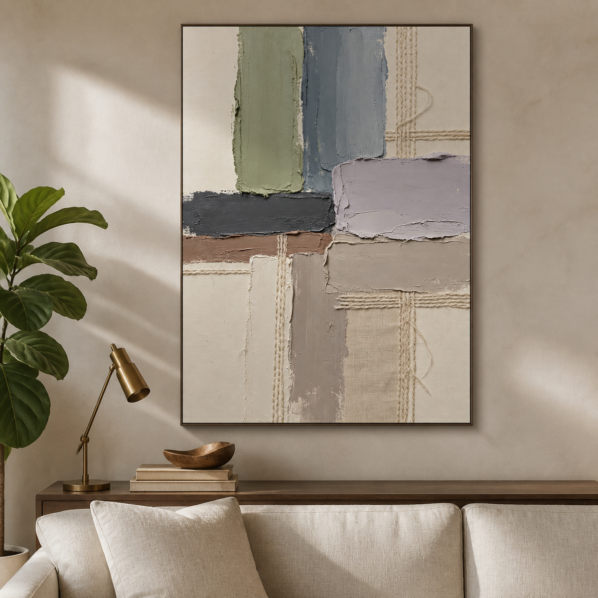 Vertical neutral textured wall art with sage, slate gray, lavender and ivory geometric blocks and woven details displayed above a sofa.
