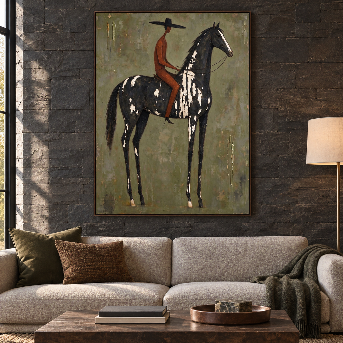 A rusty red rider in a black hat on a black and white horse against a gray-green background with gold accents, in a mountain-style living room.
