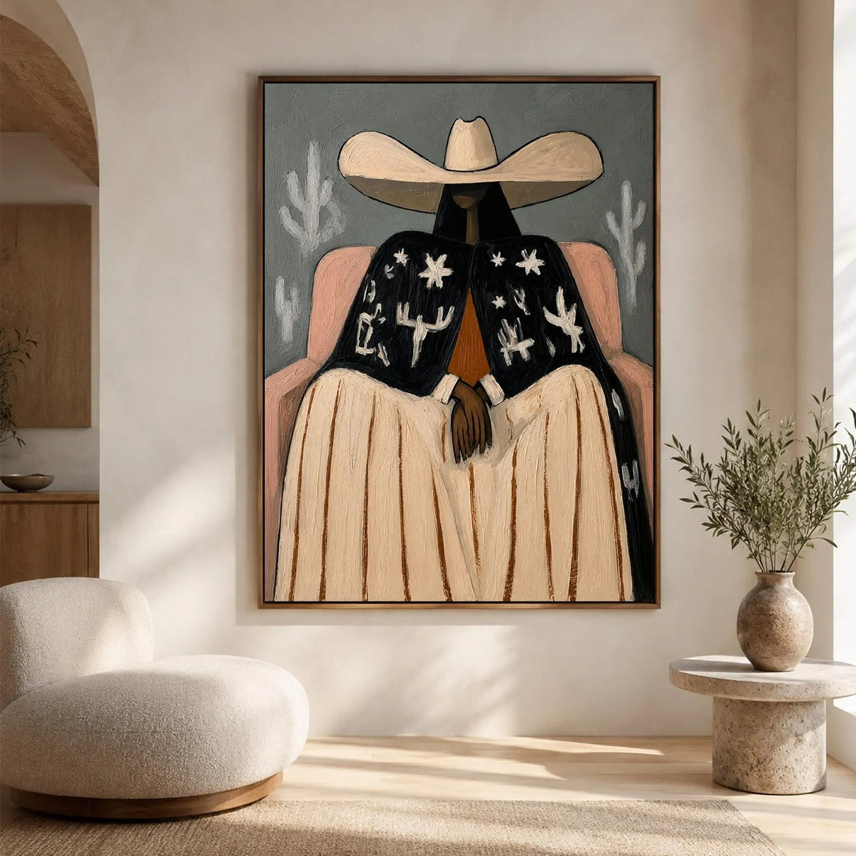 A seated cowgirl in a broad cream hat, pale skirt and black jacket patterned with white desert motifs against a gray background, shown in room setting 1.