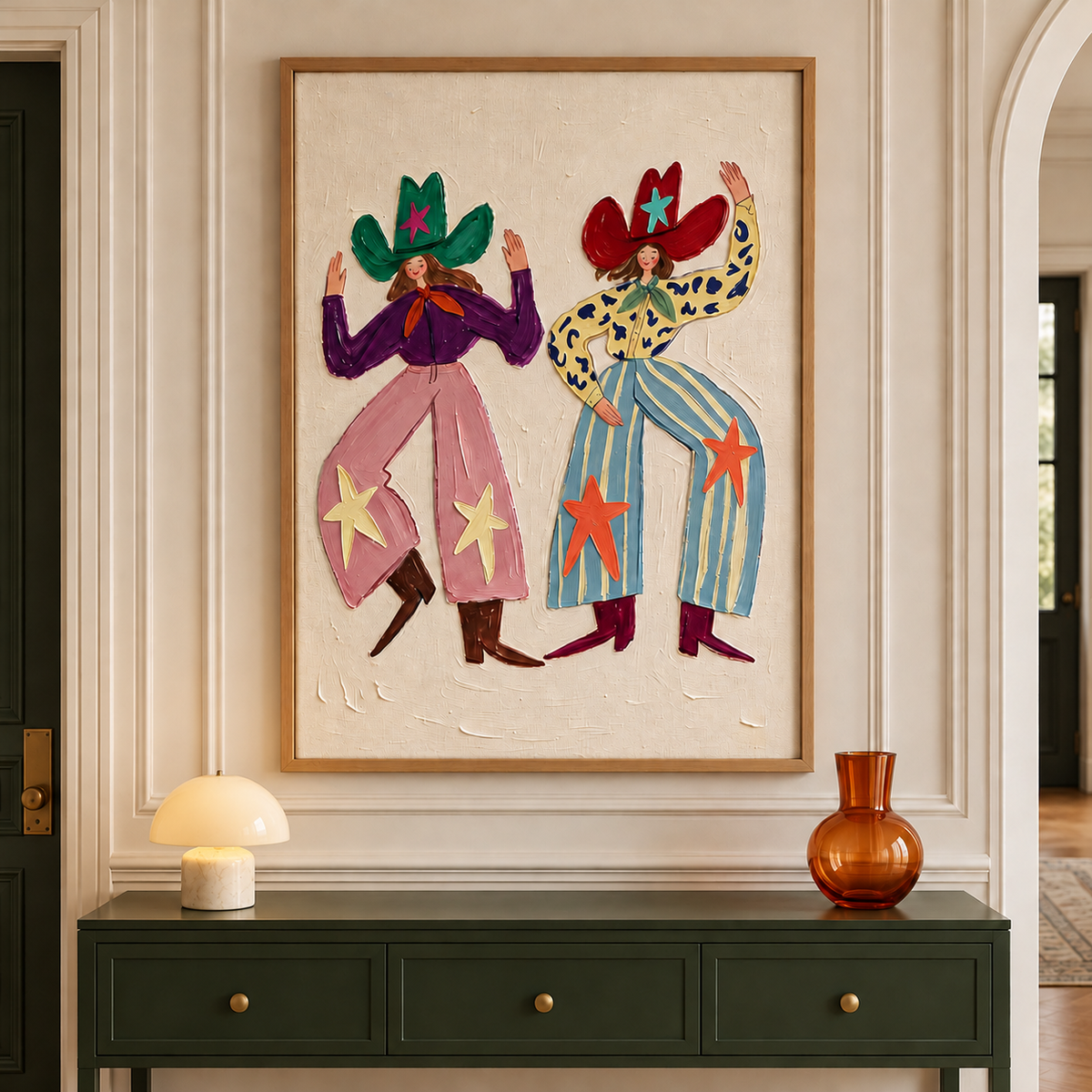 Two smiling cowgirls dancing with raised arms in oversized green and red star-decorated hats, pink and blue patterned pants and pointed boots on a cream background, shown in room setting 2.