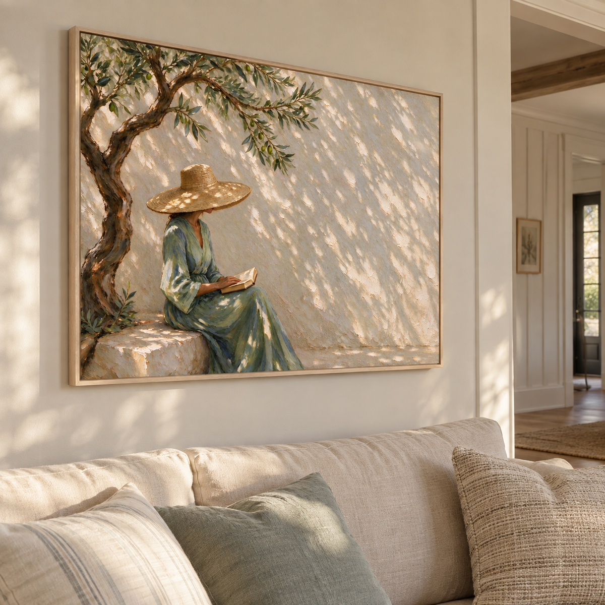 A woman in a straw hat and green dress holding an open book beneath a twisting tree with dappled sunlight on a pale wall, shown from an angle in the room.