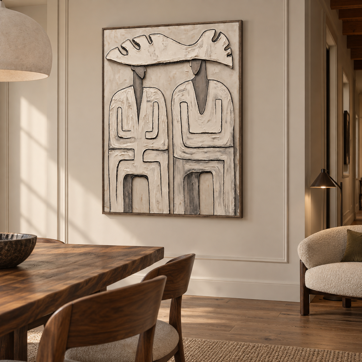 Two abstract figures beneath a single wide pale hat with dark geometric outlines on a warm neutral background, shown from an angle in the room.